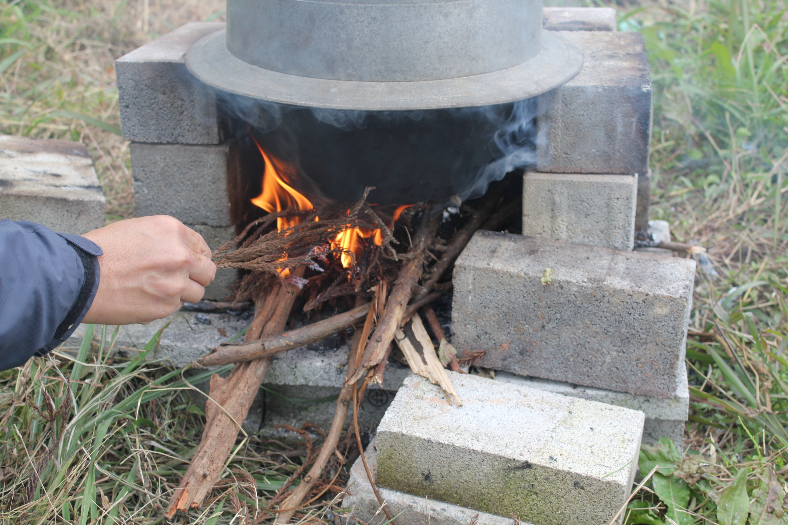 火を起こし、釜で炊いている様子