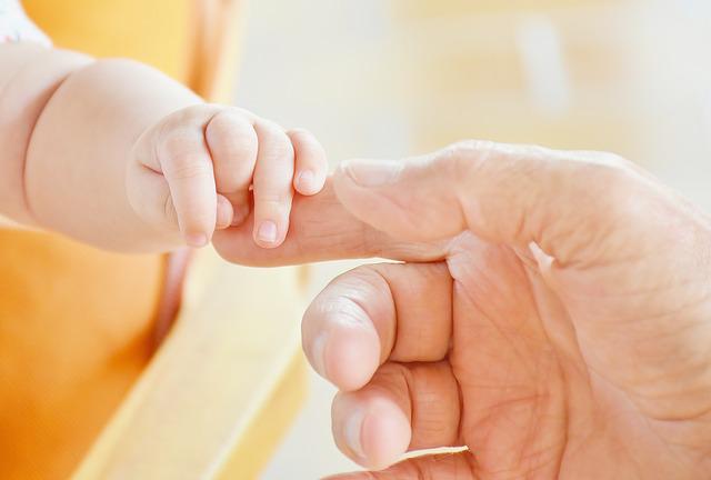 子どもの手を握る大人の手